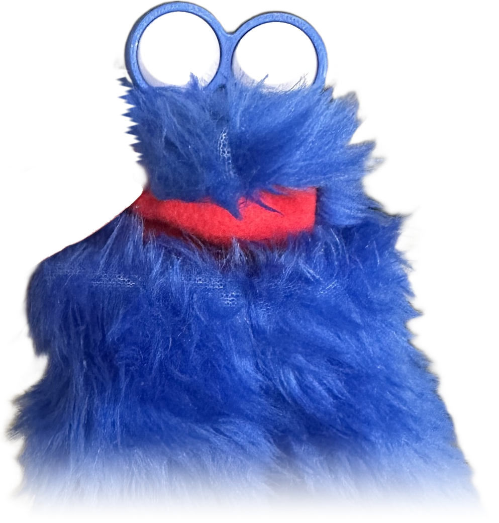 A tall, shaggy, bright blue handmade puppet with two oversized googly eyes and a red felt mouth.
